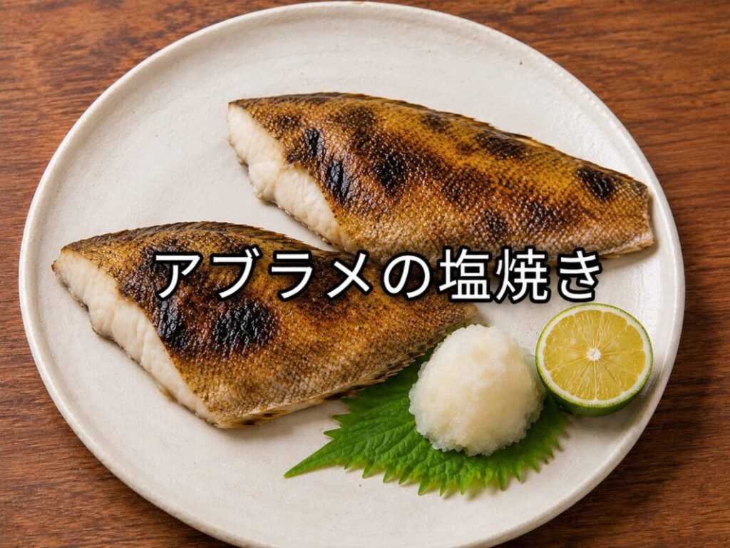 白い皿に盛り付けたアブラメの塩焼き。大根おろしとすだちを添えた和風の焼き魚料理。