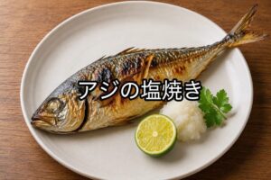 白い皿に盛り付けたアジの塩焼き。すだちと大根おろしを添えた焼き魚の料理写真。