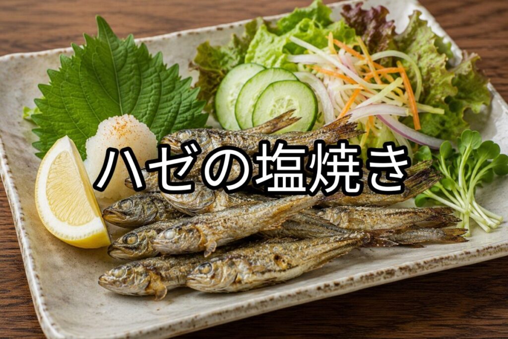 ハゼを複数匹こんがり塩焼きにし、野菜を添えて盛り付けた和風の料理写真