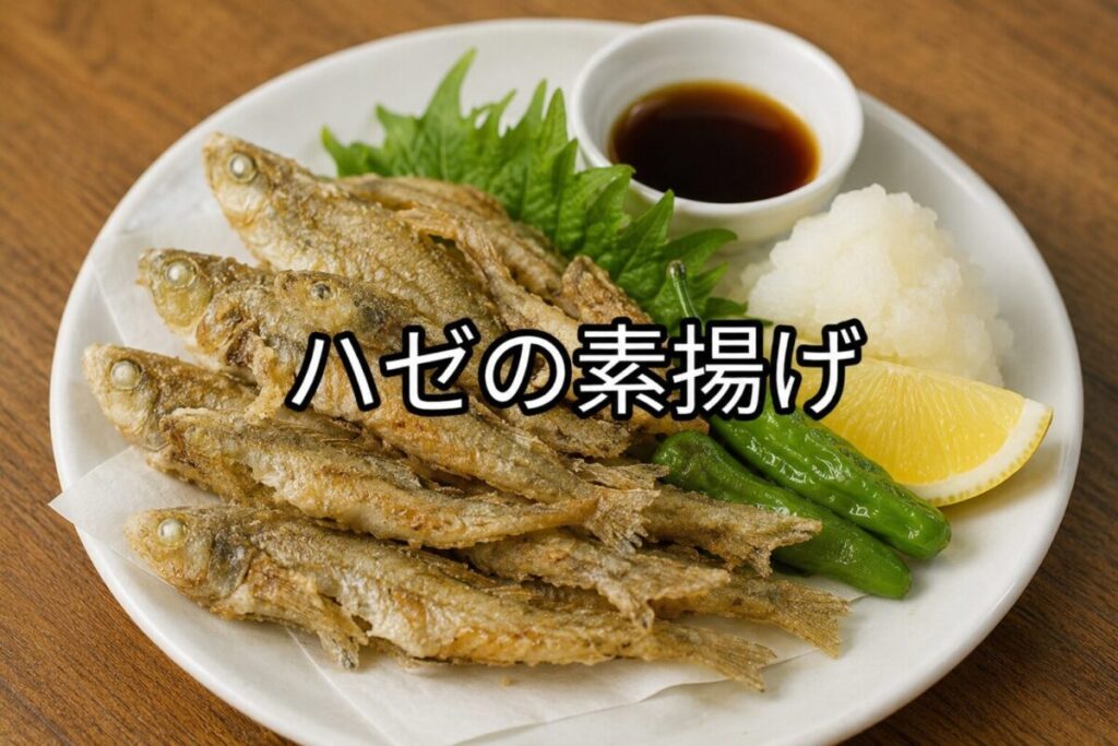 ハゼの素揚げを複数盛り付けた白い丸皿。野菜の付け合わせとレモン、大根おろしを添えた和風料理のアイキャッチ画像