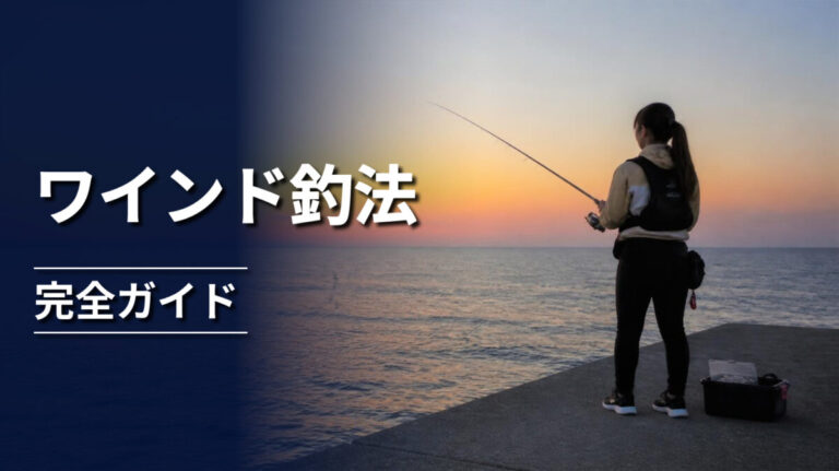 夕暮れの堤防でワインド釣法を行う釣り人