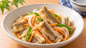揚げたハゼの切り身を玉ねぎ、にんじん、ピーマンと甘酢に漬けた南蛮漬けの料理写真