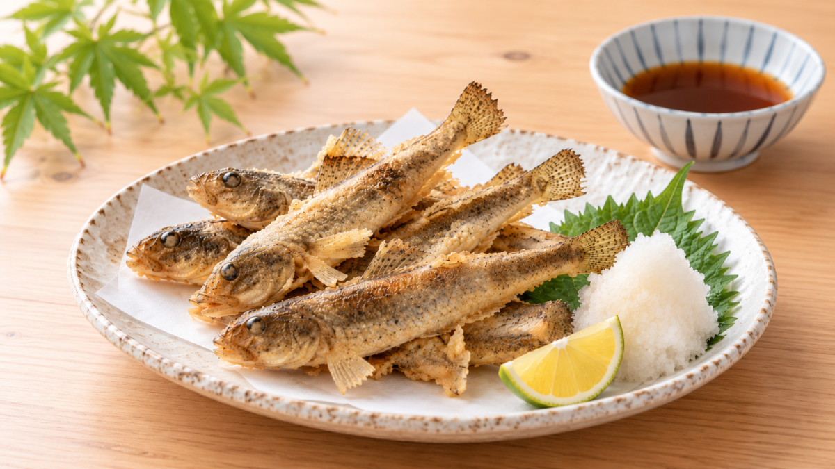 小ぶりのハゼを衣を付けずにカリッと素揚げにし、大葉、大根おろし、レモンを添えた料理写真